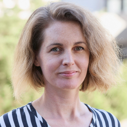 Portrait einer weiblich gelesenen, weissen Person mit halblangen Haaren.