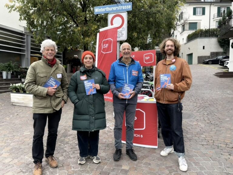 4 Personen stehen vor einem Stand mit SP-Logo